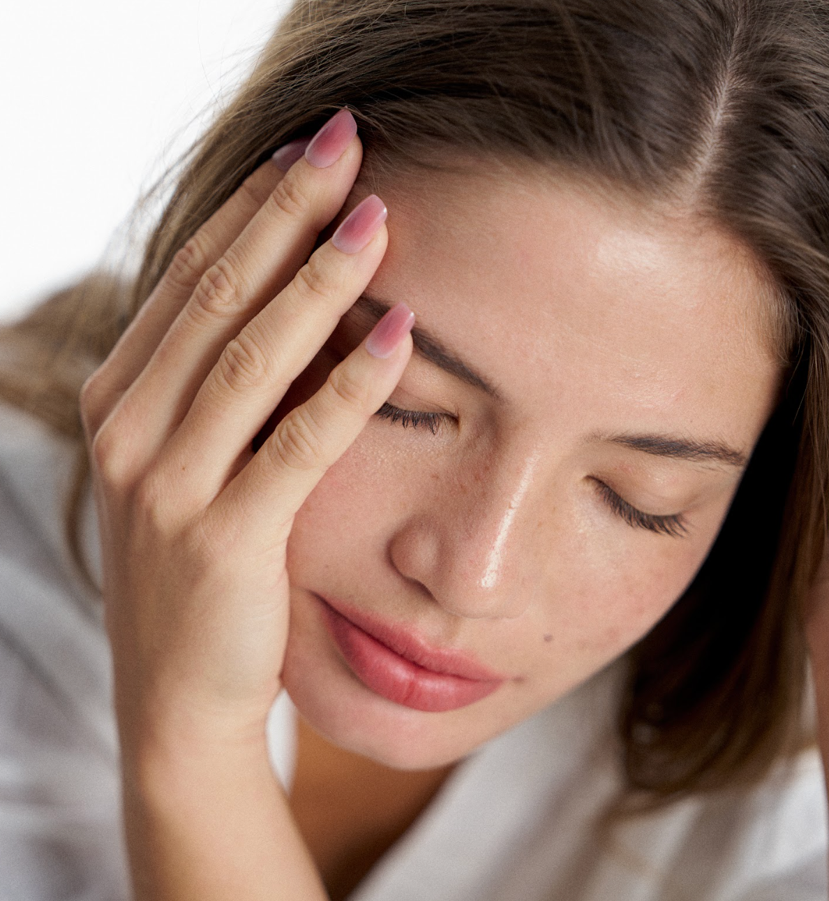 Jeune femme touchant son visage avec des ongles vernis effet peau naturel