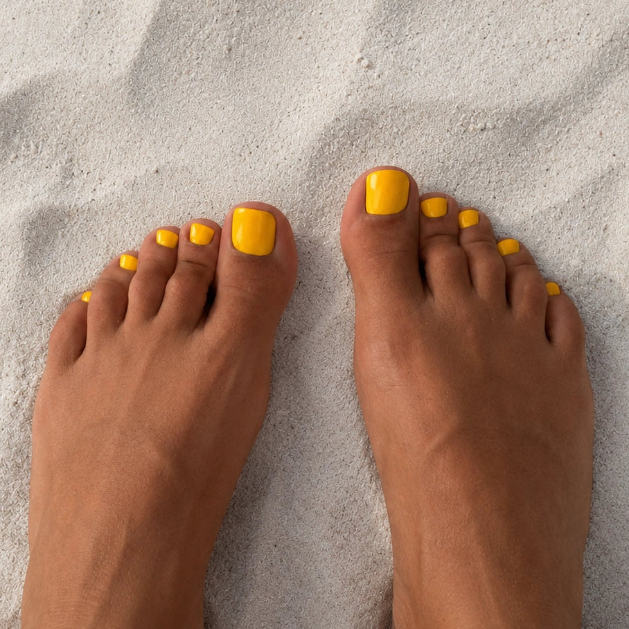 Pédicure Citron Jaune press-on Jaune clair portée sur les orteils. Faux ongles pour les pieds effet miroir, naturel. Par SOIMEA Paris