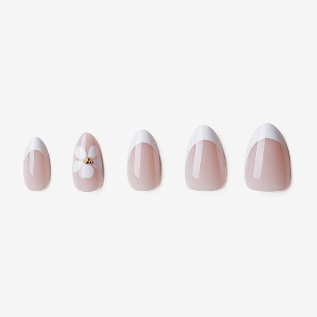 Manucure Eveil Nymphal portée sur la main. Teinte rose, blanc au motif floral. faux ongles press-on en forme amande. Par SOIMEA Paris