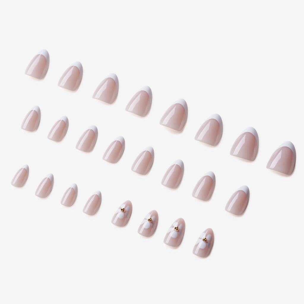 Manucure Eveil Nymphal portée sur la main. Teinte rose, blanc au motif floral. faux ongles press-on en forme amande