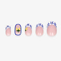 Faux ongles press-on Maiolica courts ronds avec base nude, motifs bleu profond et blanc façon céramique italienne, citrons jaunes et French revisitée