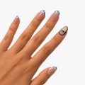 Faux ongles press-on Maiolica courts ronds avec base nude portes sur les mains, motifs bleu profond et blanc façon céramique italienne, citrons jaunes et une manucure française revisitée. Par SOIMEA Paris