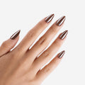 Manucure L'ivresse portée sur la main. Teinte marron. Faux ongles press-on en forme amande effet brillant naturel. Par SOIMEA Paris