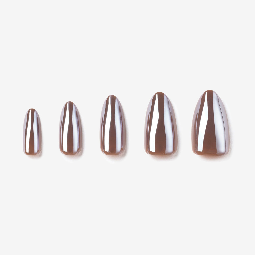 Manucure L'ivresse portée sur la main. Teinte marron. Faux ongles press-on en forme amande effet brillant naturel. Par SOIMEA Paris