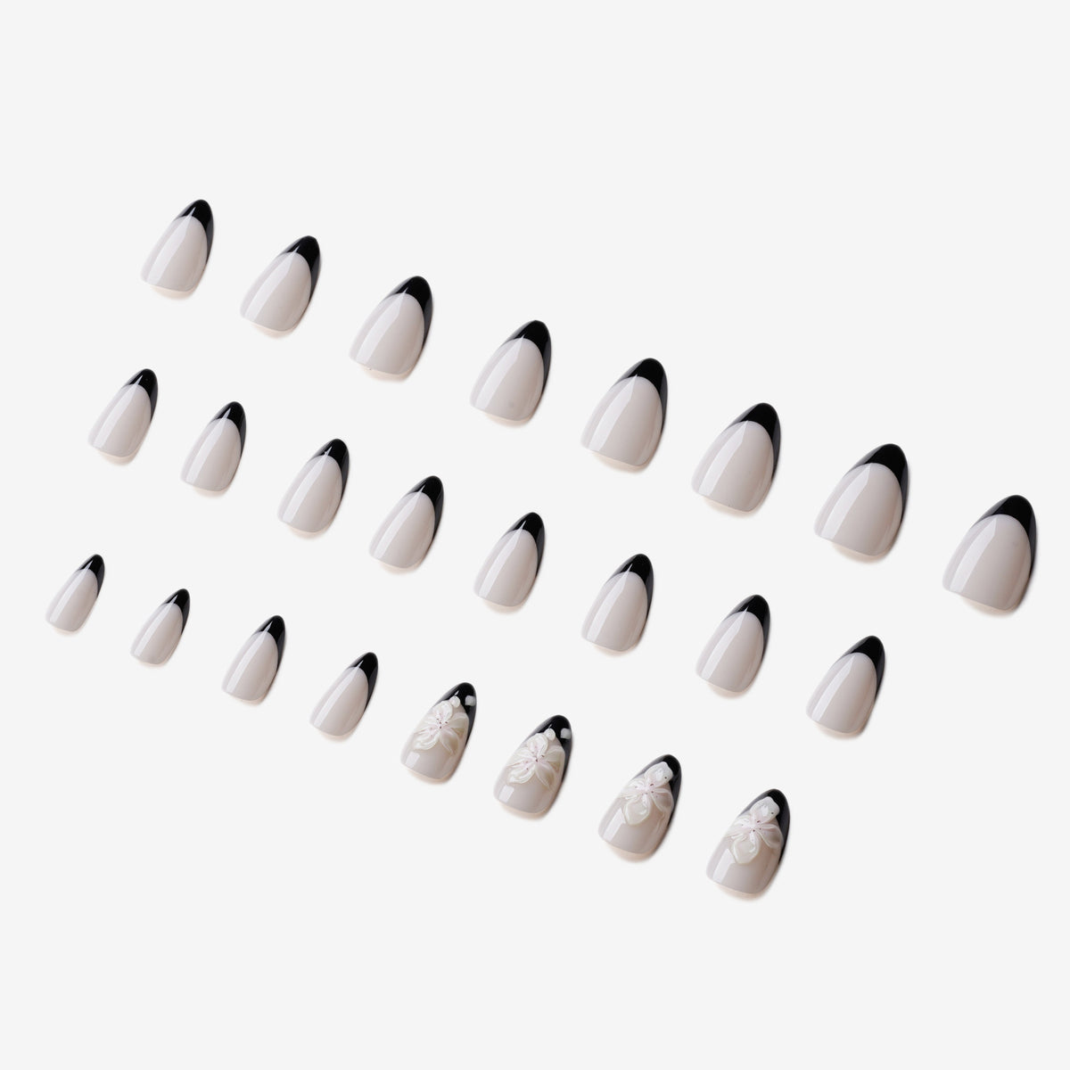 Manucure La Couronne d’Ophélie  portée sur la main. Teinte blanc, noir au motif floral. Faux ongles press-on en forme amande. Par SOIMEA Paris