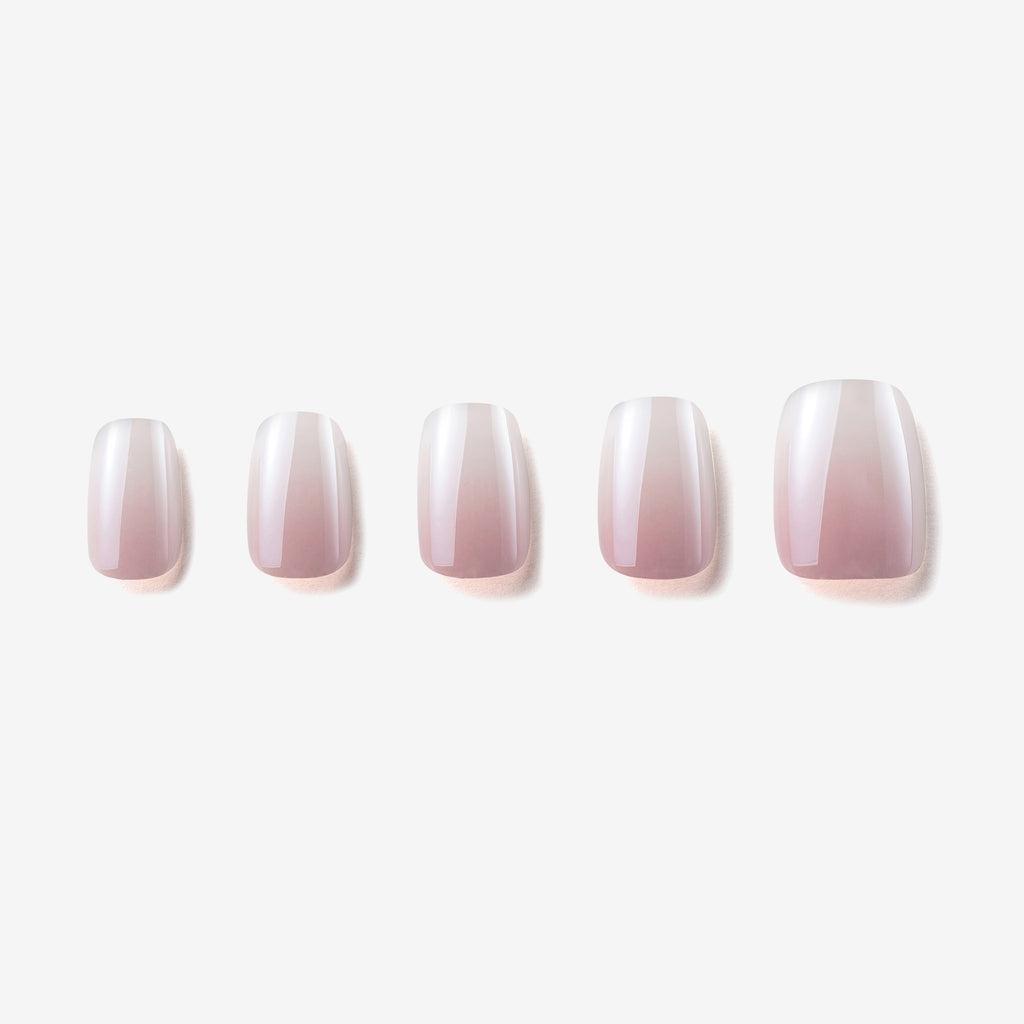 Manucure Le ciel rose portée sur la main. teinte rose, blanc. Faux ongles press-on effet brillant naturel. Par SOIMEA Paris