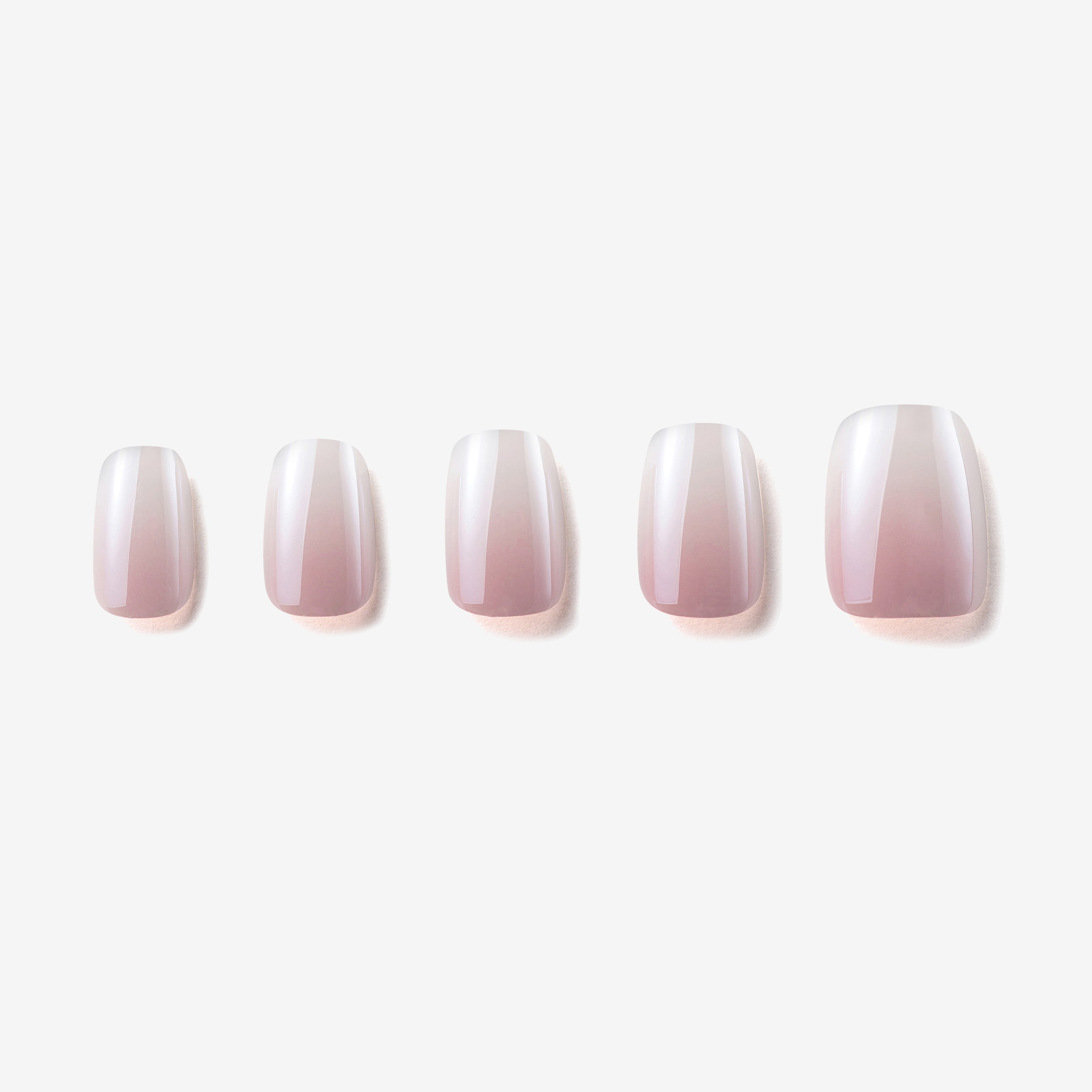 Manucure Le ciel rose portée sur la main. teinte rose, blanc. Faux ongles press-on effet brillant naturel. Par SOIMEA Paris