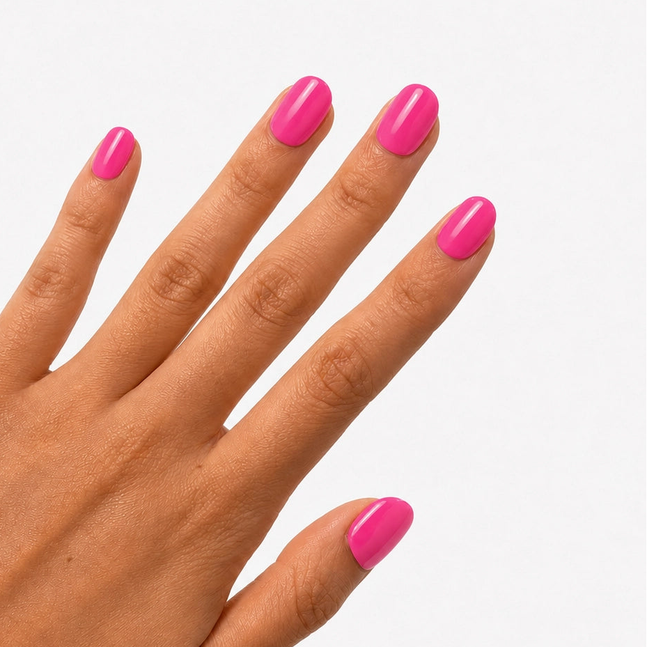 Manucure Rose Fuchsia portée sur la main, faux ongles press-on courts arrondis rose vif brillant et féminin