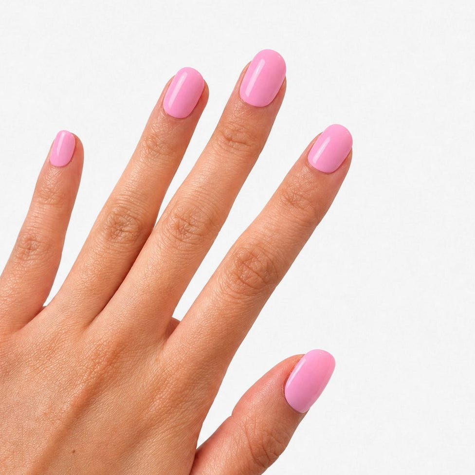 Manucure Rose Pêche portée sur la main, faux ongles press-on courts arrondis rose pêche brillant et naturel