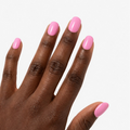 Manucure Rose Pêche portée sur la main teinte fonce, faux ongles press-on courts arrondis rose pêche brillant et naturel. Par SOIMEA Paris
