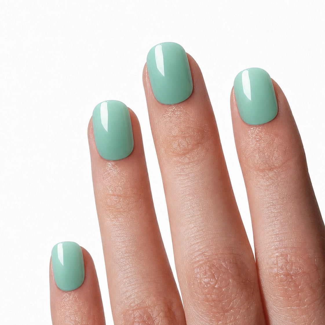 Manucure press-on Vert Menthe portée sur la main, faux ongles courts arrondis vert pastel brillant et frais