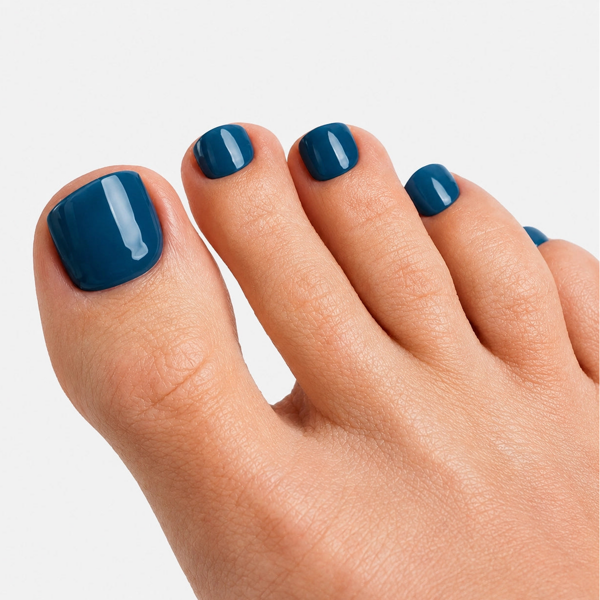 Pédicure Bleu Ocean press-on bleu fonce portée sur les orteils. Faux ongles pour les pieds effet naturel. Par SOIMEA Paris