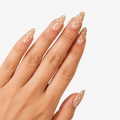 Manucure Chouchette portée sur la main. Teinte beige avec motif à pois blanc. Faux ongles press-on en forme d'amande. Effet brillant naturel. Par SOIMEA Paris